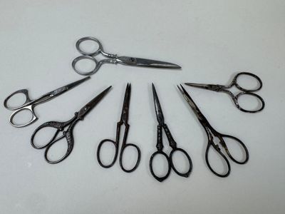 several pairs of scissors are arranged in a circle on a white surface