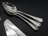 four spoons and a fork on a black table
