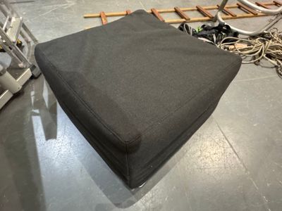 un pouf noir posé à même le sol dans une pièce