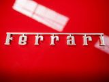 a close up of a car emblem on a red surface