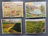 four paintings of a landscape hanging on a wall in a room