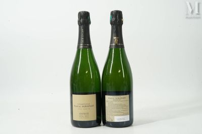 deux bouteilles de champagne posées l'une à côté de l'autre sur une surface blanche