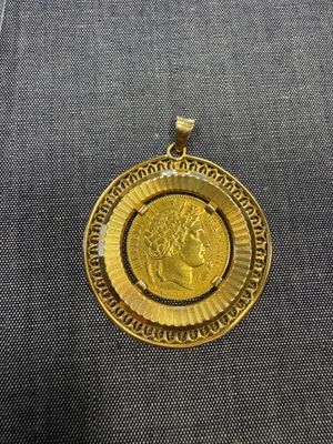gros plan d'une pièce d'or avec un visage dessus