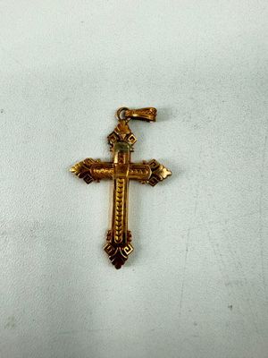une croix dorée sur un tissu blanc orné d'une croix
