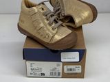 a pair of gold shoes sitting on top of a cardboard box