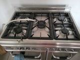 a gas stove with two burners and a hose on the burner
