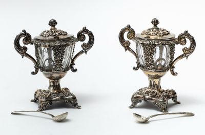 two silver vases with spoons and spoons on them