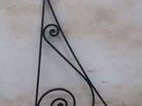 a black wrought iron bracket on the side of a building