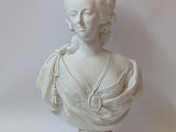 a white bust of a woman with a necklace on it