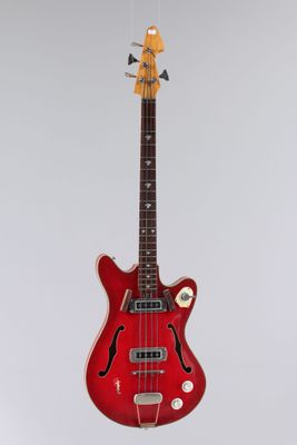 une guitare électrique suspendue à une ficelle sur un mur blanc
