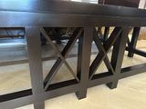 a wooden table with a black top on the floor