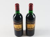 two bottles of wine sitting next to each other on a white surface