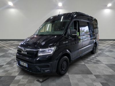 la camionnette noire est garée sur un sol en damier dans le garage