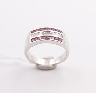 a close up of a pink sapphire and diamond ring on a white background