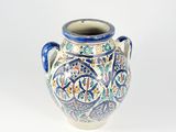 un vase bleu et blanc posé sur une surface blanche