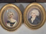 two framed portraits of a man and a woman in formal clothing