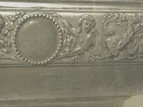 a silver vase with a design on it on a table