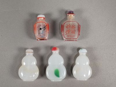 quatre petites bouteilles en verre sont alignées sur une surface grise