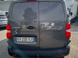 the back of a grey van parked in a lot next to a building