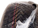 a bag of black yarn wrapped in plastic on a white surface