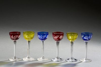 four wine glasses are lined up in a row on a table