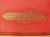 an old red book with a gold arrow on the cover