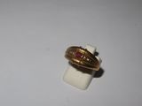 a gold ring with a red stone on top of it