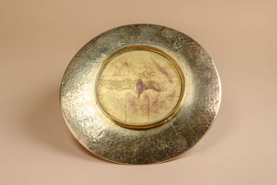 a silver plate with a picture of a woman on it