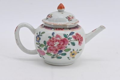 une théière blanche ornée d'un motif de fleurs roses