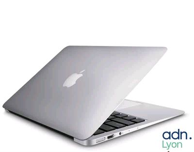 un ordinateur portable Apple blanc posé sur une table blanche