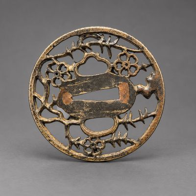 une plaque en bronze ornée d'un oiseau et de fleurs