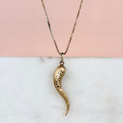 un collier en or avec un pendentif en forme de serpent sur une chaîne