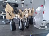three vases with dried plants in them sitting on a table