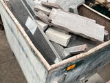 un gros tas de blocs de granit dans un conteneur métallique