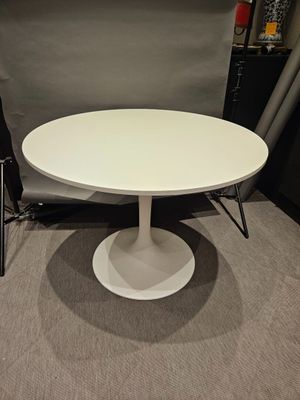 the table is white and has a black chair in front of it