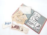 un livre ouvert posé sur une table blanche, à côté d'une pile de timbres