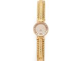a close up of a gold wrist watch with a chain around it