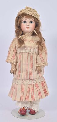 an old fashioned doll with a hat and dress on a white surface