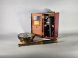 une petite boîte en bois sur laquelle sont représentés un télescope et une boussole