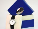 une boîte bleue sur laquelle est représentée une montre et qui contient une cuillère