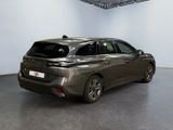 the rear of a grey car is parked in a large room