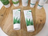 many different types of skin care products sitting on a wooden tray