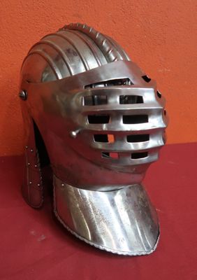 un casque argenté sur un fond rouge, avec un mur en arrière-plan