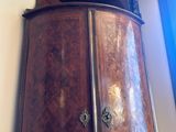 a tall wooden cabinet in the corner of a room