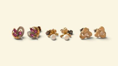 trois paires de boucles d'oreilles sont disposées en rangée sur une surface blanche