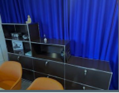 a picture of a room with a blue curtain and a desk