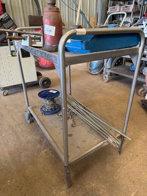 un chariot métallique sur lequel se trouve un plateau bleu, dans un garage