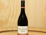 une bouteille de vin posée sur un tonneau