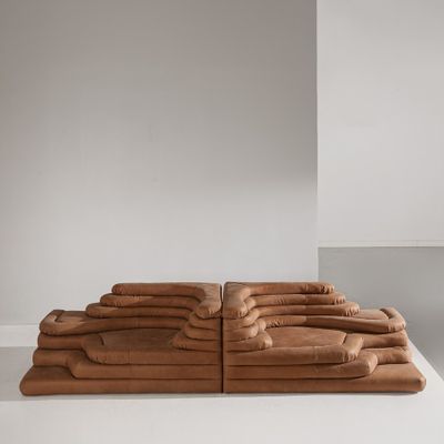 un canapé en cuir marron posé sur une table blanche