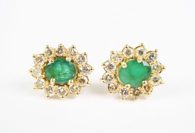 a pair of emerald and diamond earrings